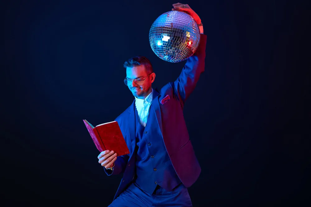 Robin Rehmann mit Trauredner-Buch und Discokugel